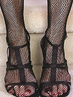 Redheaded grandma in a fishnet body stocking plays with her feet